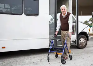 Man exiting a shuttle bus with a walker